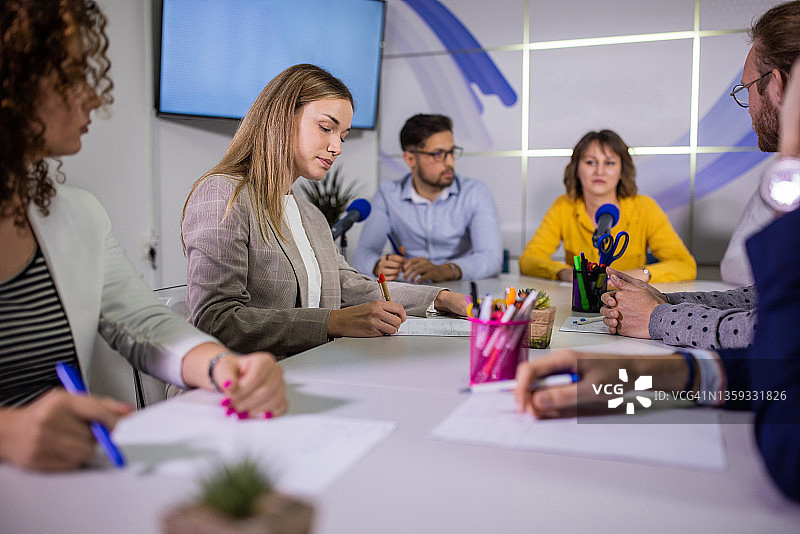 一群记者在媒体中心的记者招待会上做笔记图片素材