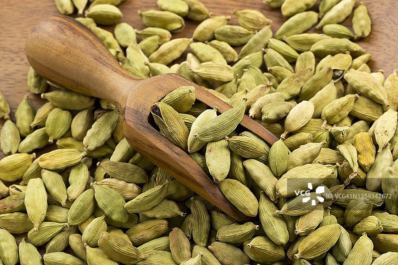 木碗和木勺中的豆蔻荚果图片素材