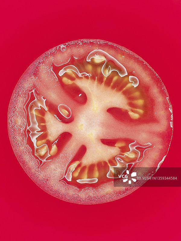红色表面上的番茄切片特写图片素材