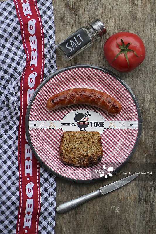 纸盘上的烤香肠和面包片（俯视）图片素材