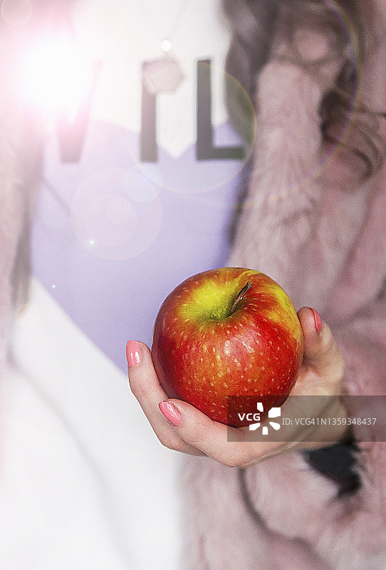 女性手持的红色和绿色苹果图片素材
