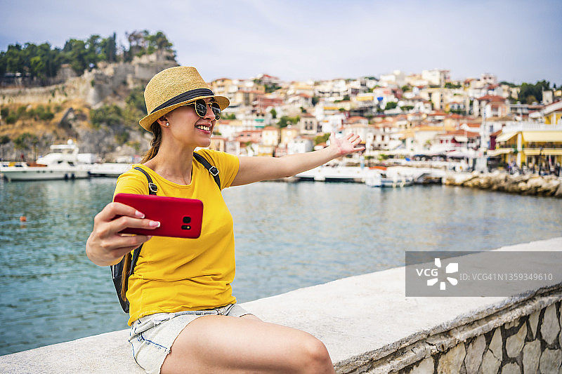 年轻女人在海边录制视频博客。图片素材