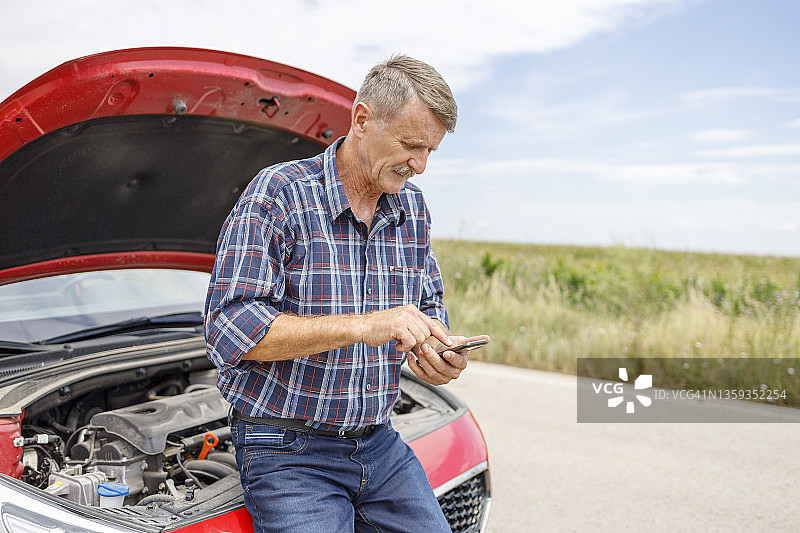 年长的男人拨打路边救援电话图片素材