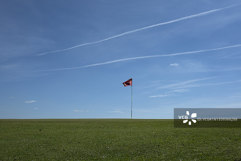 蓝天下高尔夫球场的红旗图片素材