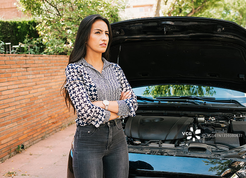 不满的司机站在抛锚的汽车旁图片素材