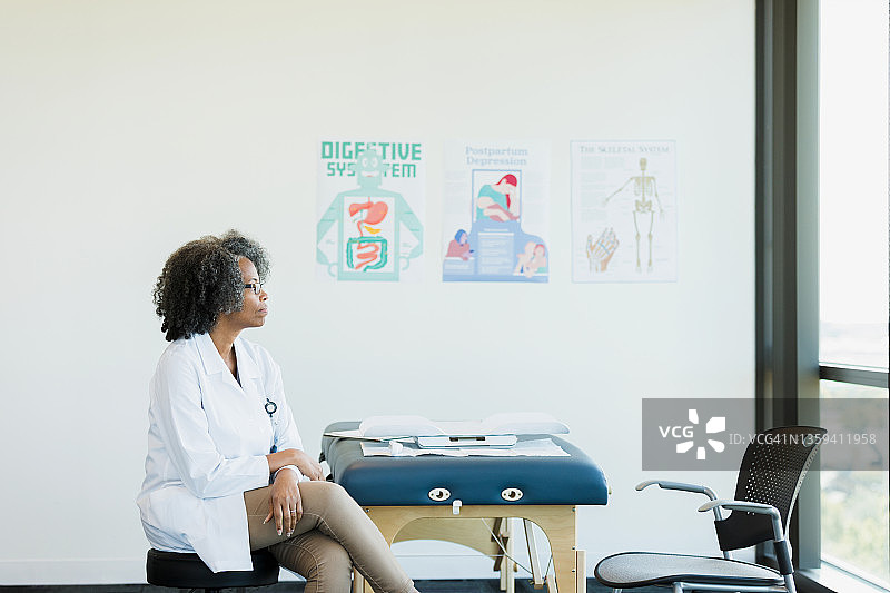 女医生在等待下一位病人时做白日梦图片素材