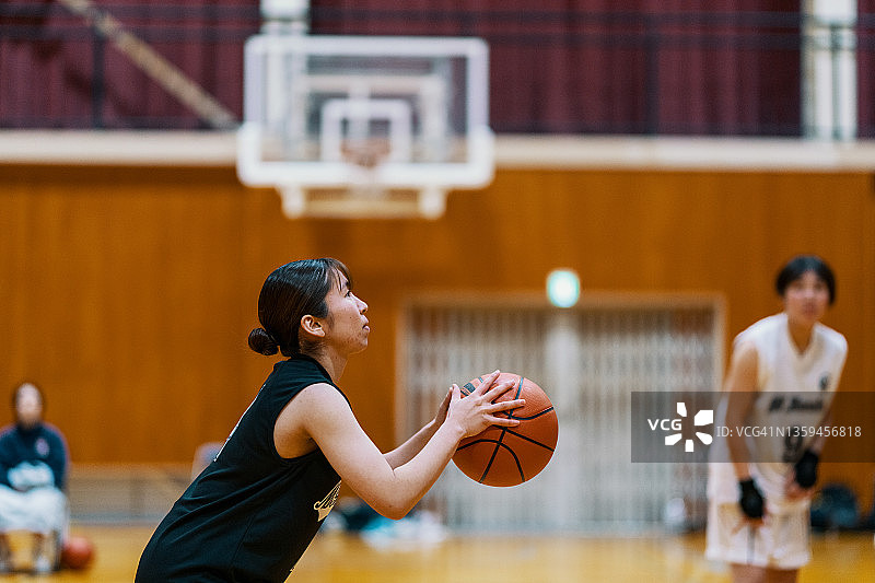 年轻的日本女大学生篮球运动员罚球图片素材