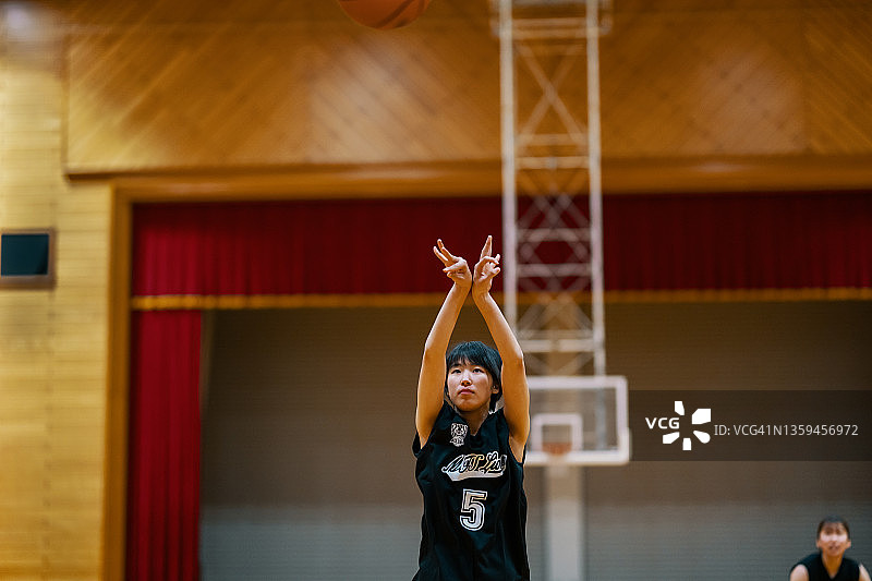年轻的日本女大学生篮球运动员罚球图片素材