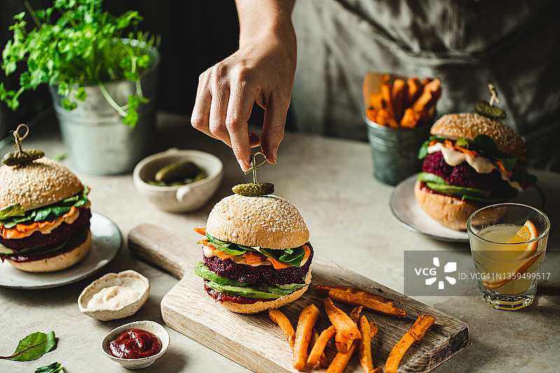 女人准备美味的纯素汉堡和红薯图片素材