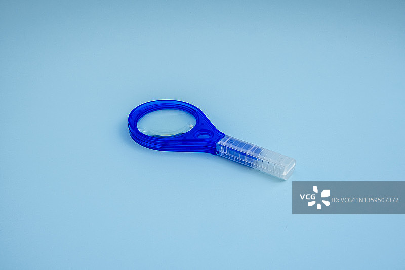 蓝色背景上的放大镜图片素材