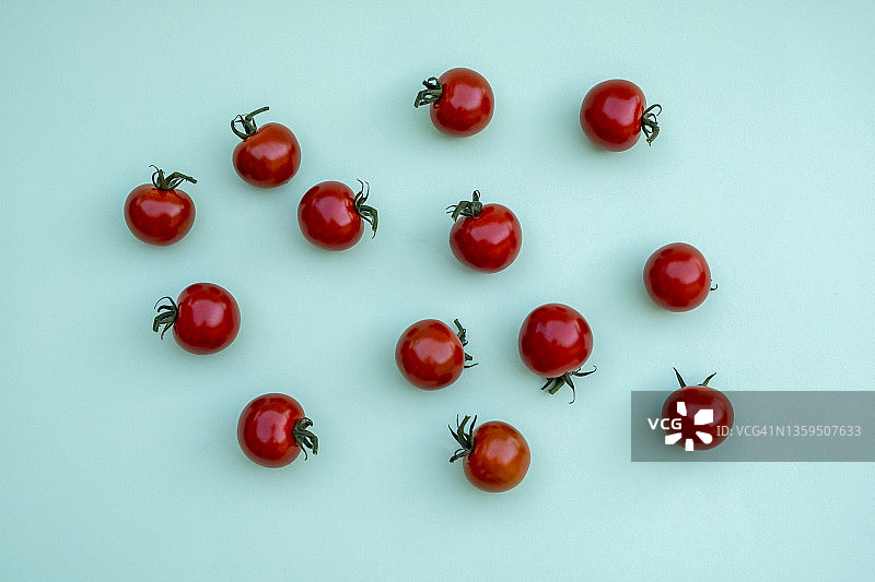 薄荷蓝色背景上的樱桃番茄图片素材
