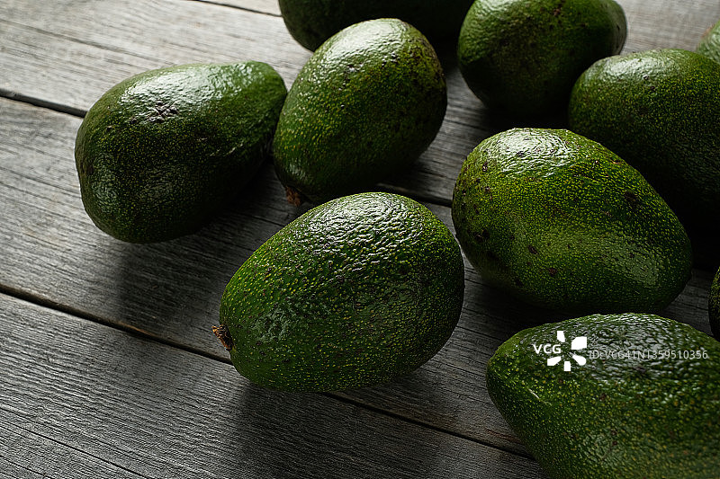 木桌上的绿色成熟牛油果，素食主义概念图片素材