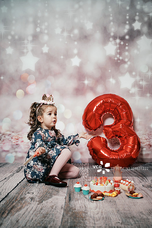 女孩用塑料刀切不开她的玩具蛋糕图片素材