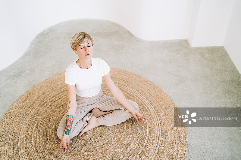 自然纹身女人在简约家居中冥想图片素材