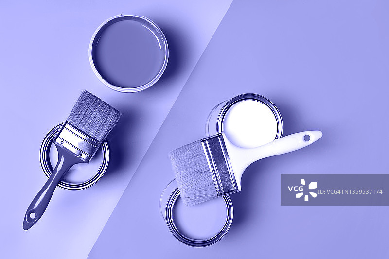 淡紫色背景上的四罐淡紫色和白色油漆与画笔图片素材