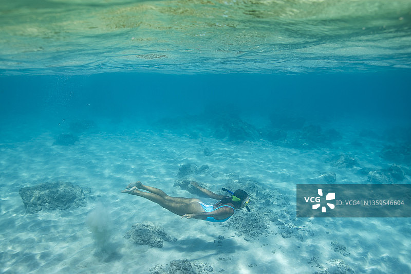 在蓝色夏威夷水域中水下游泳的女人图片素材