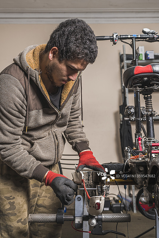 修理电动滑板车挡泥板的技工图片素材