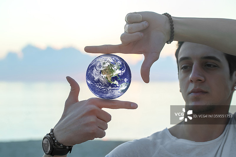 手指构图框中的行星：模仿捕捉日落时的阳光图片素材