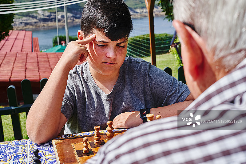 祖父和孙子在花园里下棋图片素材