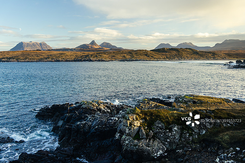 日落时分从海岸线升起的群山图片素材