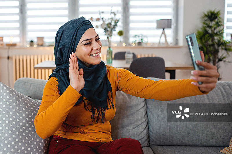 穆斯林女人在公寓里视频通话图片素材