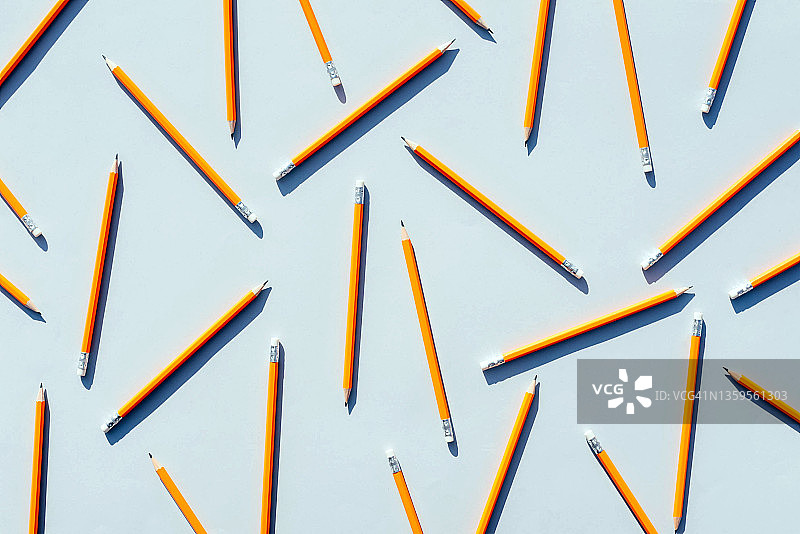 浅蓝色背景上的彩色铅笔图案。图片素材