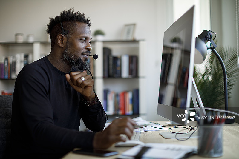 戴着耳机在家工作的男人图片素材