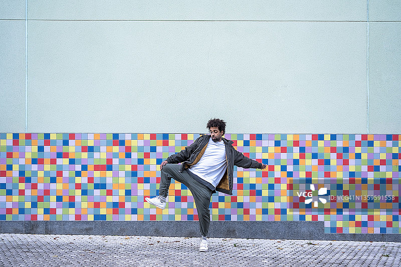 爆炸头黑人男子在彩色背景上表演现代舞图片素材