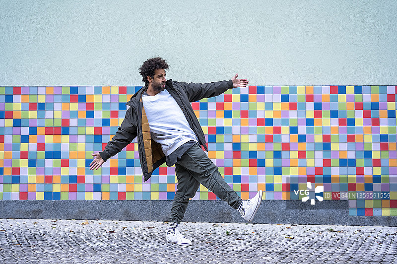 在彩色背景上跳现代舞的爆炸头黑人男子街舞舞者，留白图片素材