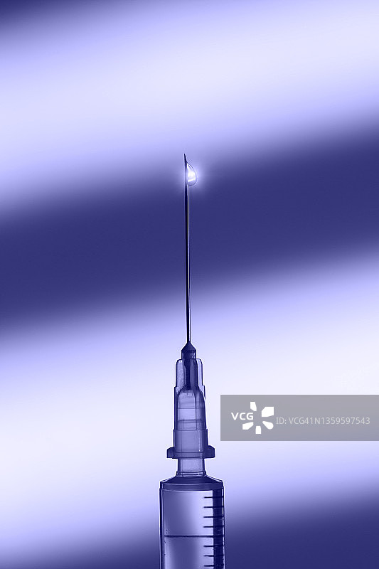 无菌注射器，细针末端有光泽的透明药物滴，紫色背景。带有复制空间的大宏观摄影。展示2022年的非常Peri颜色图片素材