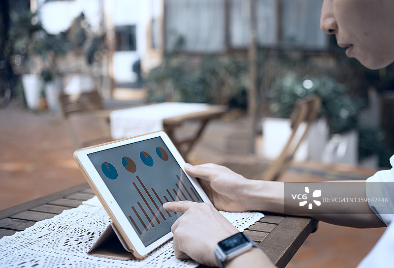 亚洲男人用平板电脑查看统计数据图片素材