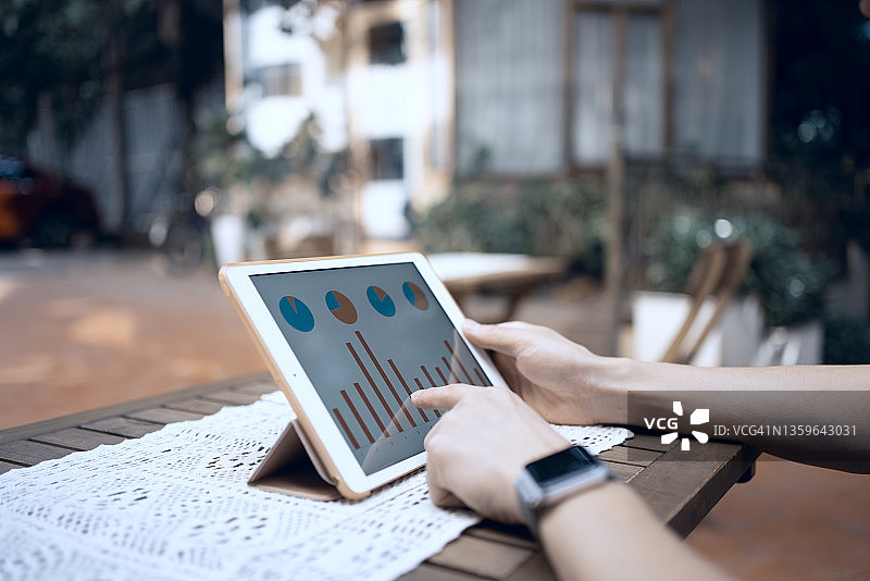 亚洲男人用平板电脑查看统计数据图片素材