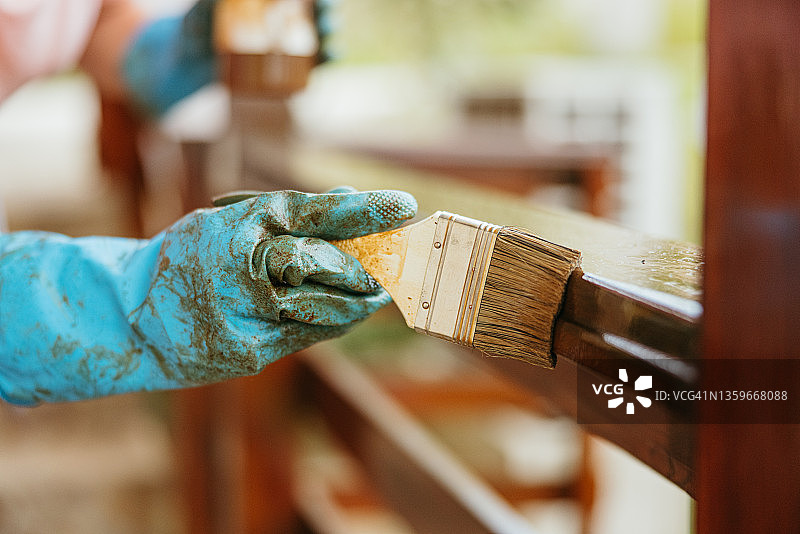 戴手套的手拿着大刷子粉刷木栅栏特写图片素材