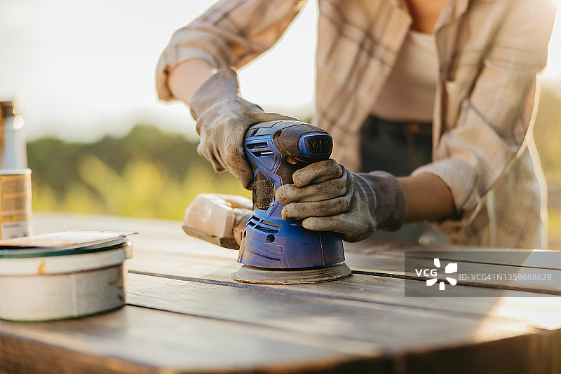 用砂光机砂光木制花园桌子特写图片素材