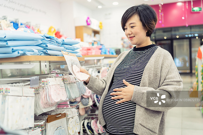 孕妇挑选婴儿服装图片素材