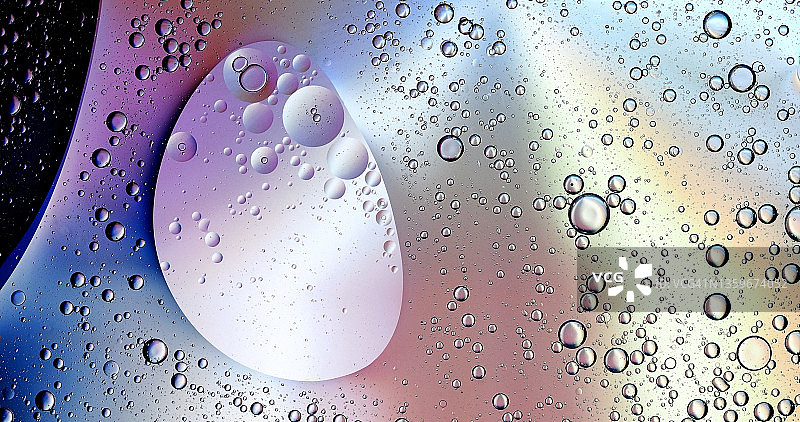 粉色液体背景上的气泡和水滴形成的抽象形状和纹理图片素材