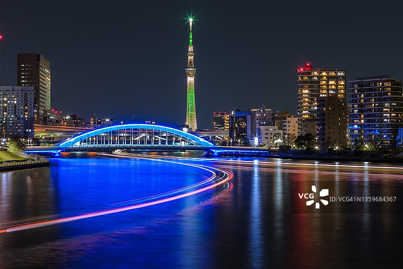 东京隅田川上，摩天大楼和船屋灯光夜景图片素材
