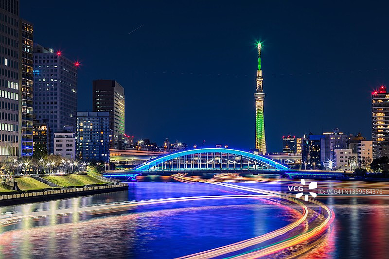 东京隅田川上，摩天大楼和船屋灯光夜景图片素材
