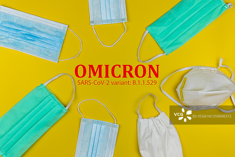 黄色背景上的医用口罩。冠状病毒感染的保护。冠状病毒COVID-19 奥密克戎变种图片素材