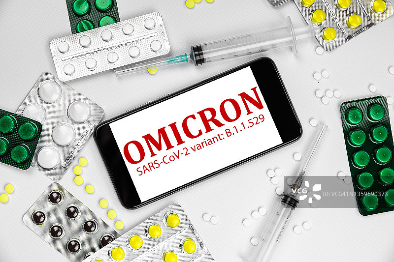 带有新冠病毒COVID-19奥密克戎变异株、药丸和疫苗的智能手机图片素材