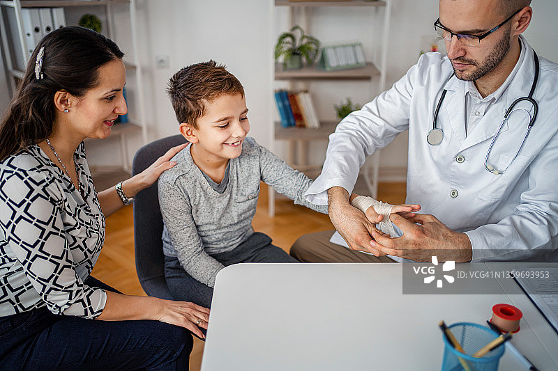 在儿科医生诊所接受手腕骨折治疗的小男孩图片素材