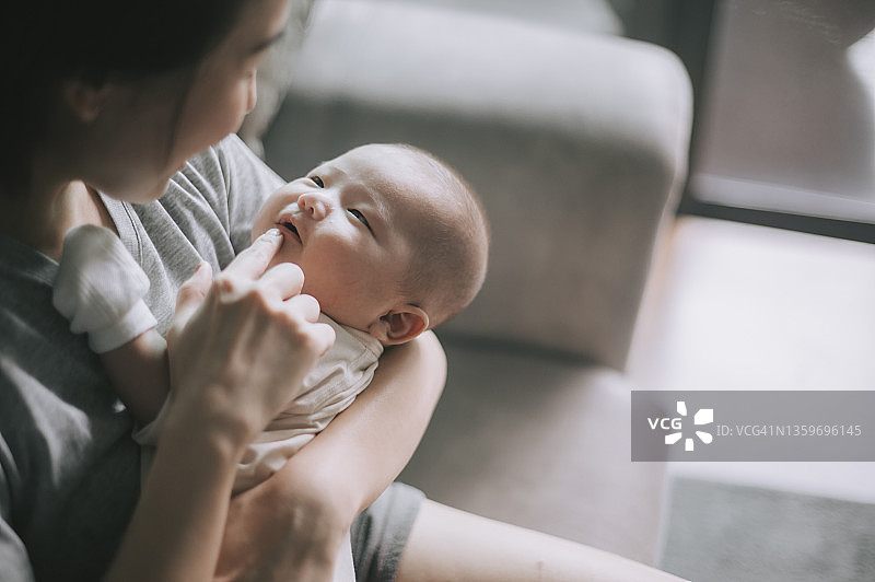 中国亚洲母亲与男婴在家中亲昵互动图片素材