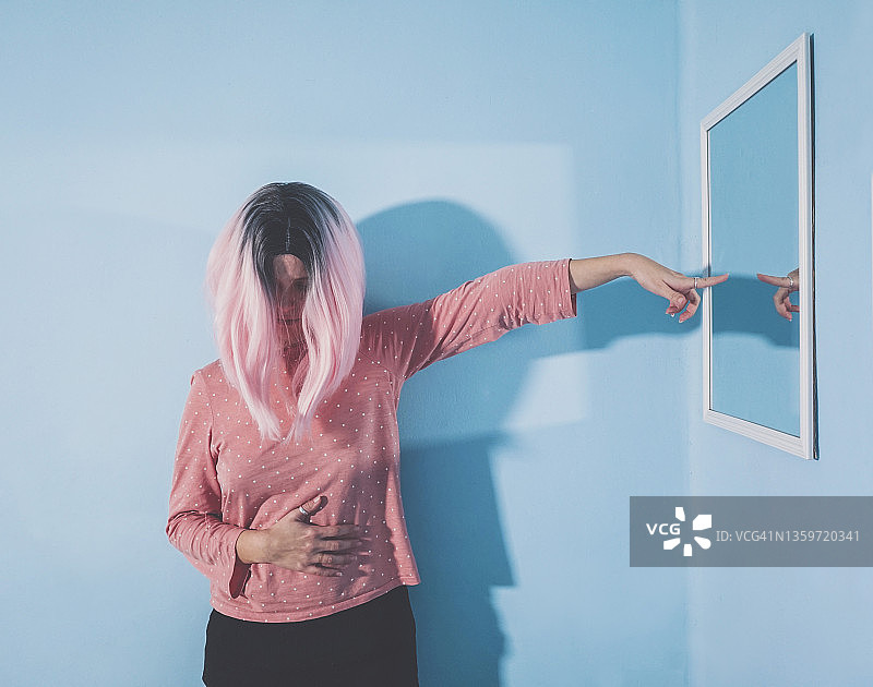 女人指着墙上的镜子图片素材