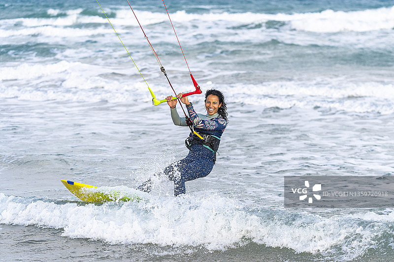 快乐的女人在水上玩风筝冲浪图片素材
