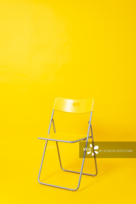 黄色背景上的空折叠椅图片素材
