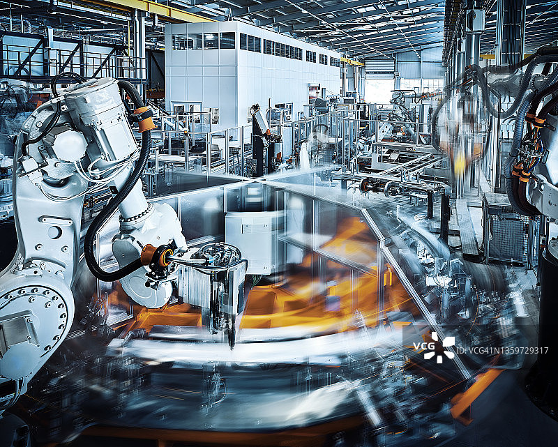 在现代化工厂内运作的机械臂图片素材