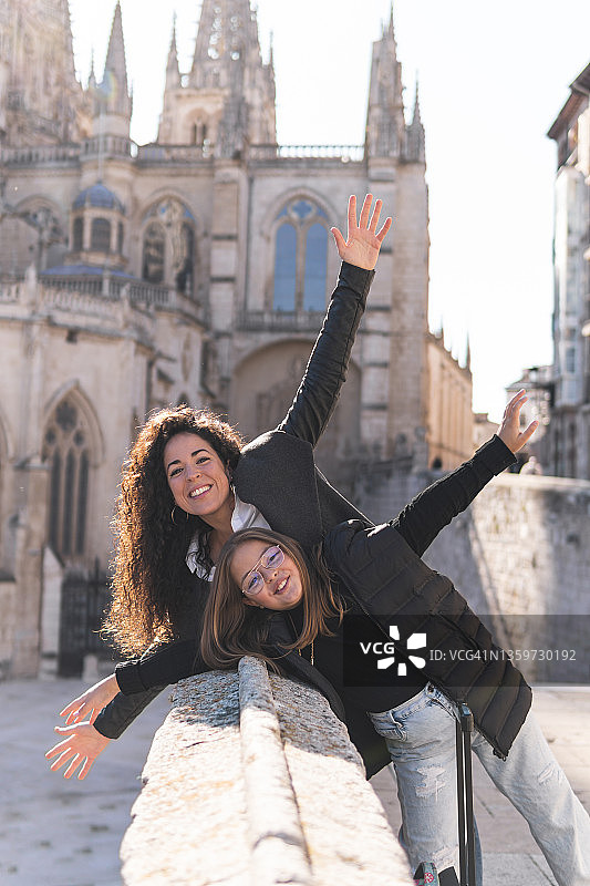 快乐的女人和女孩在西班牙布尔戈斯大教堂张开双臂图片素材