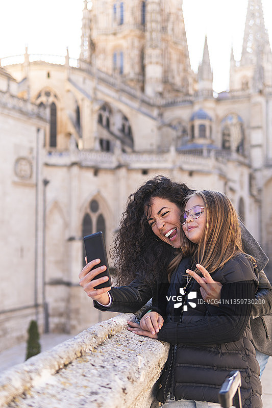 笑容满面的母亲在西班牙布尔戈斯大教堂与女儿自拍图片素材