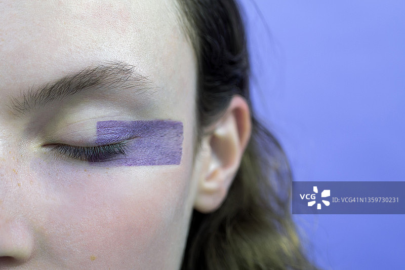 在薰衣草背景下闭着眼睛化妆的女人图片素材