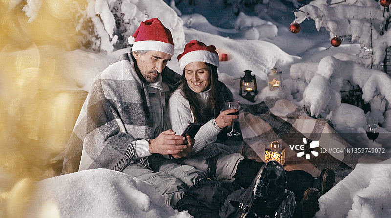 情侣在户外庆祝圣诞节，与朋友进行在线通话图片素材